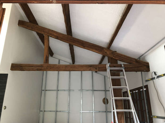 Charpente à poutres apparentes conservée lors de l'aménagement de combles — VBS Bâtiment