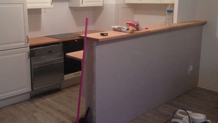 Cuisine en cours d'installation avec plan de travail et bar — VBS Bâtiment