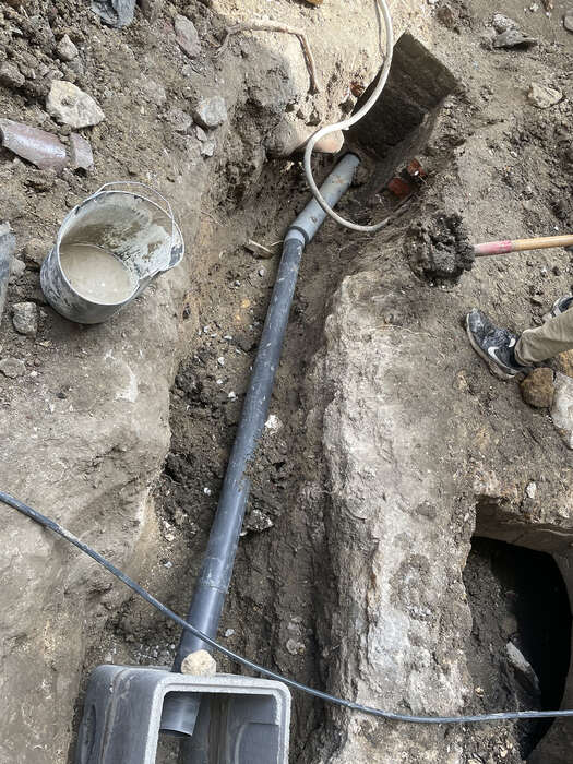 Terrassement et mise à nu d'une canalisation lors de travaux de plomberie extérieure — VBS Bâtiment